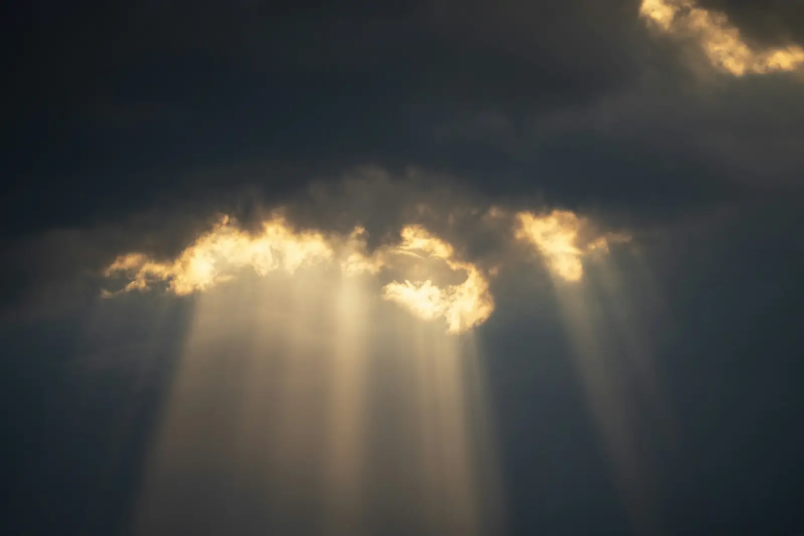 Sonnenstrahlen brechen durch dunkle Wolken